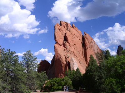 [Huge red cliff-rock projections contrast with a very blue sky with white clouds.]